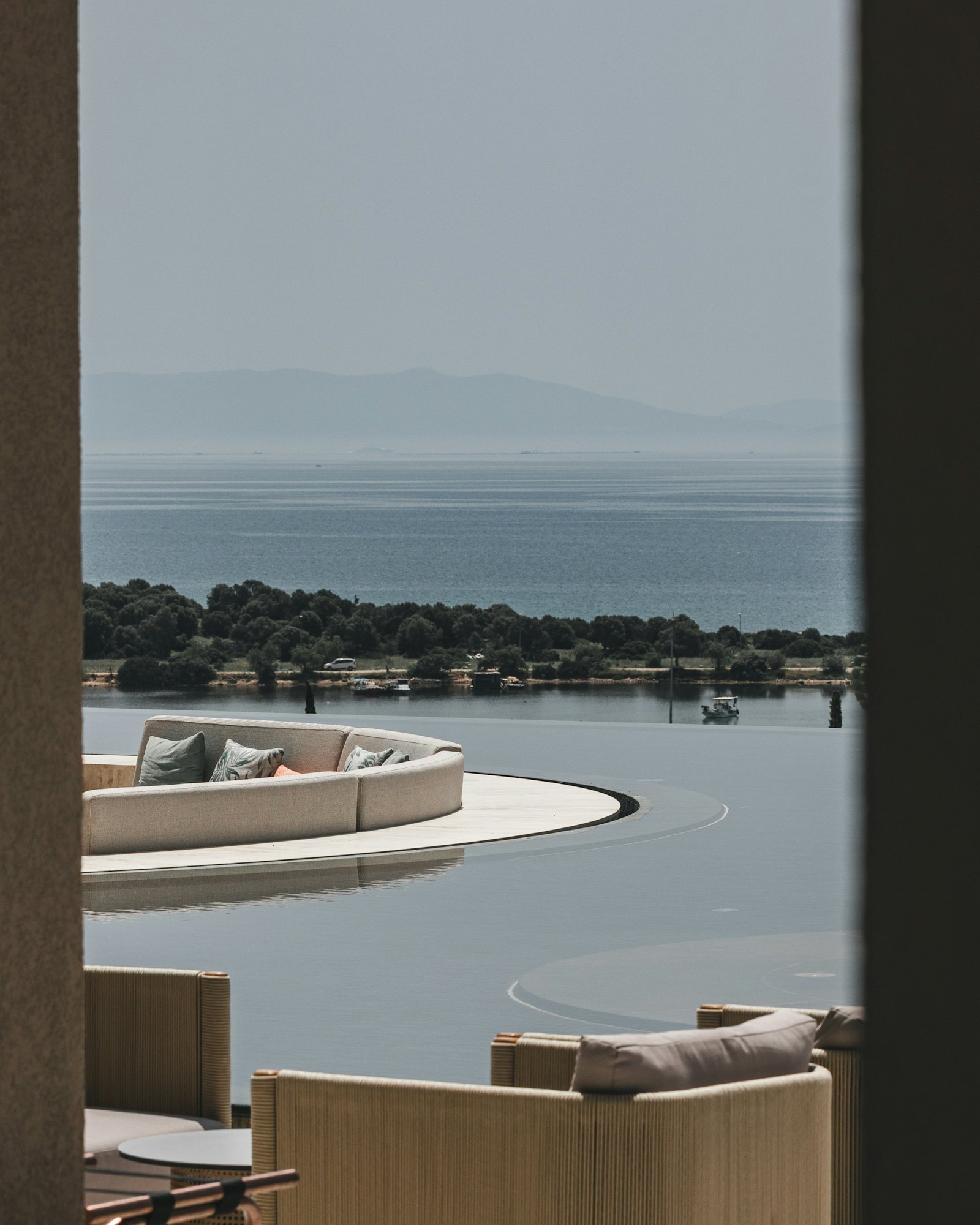 Modern outdoor lounge overlooking the sea from a villa terrace, representing Sereno Villa Care